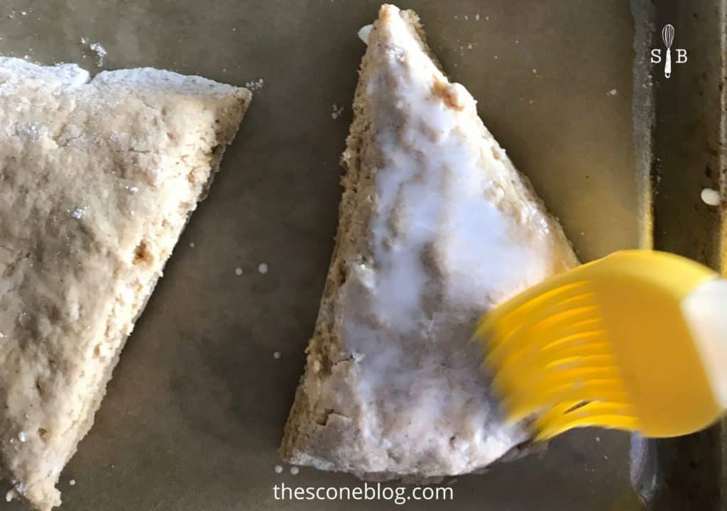 Brushing cream on top of scones