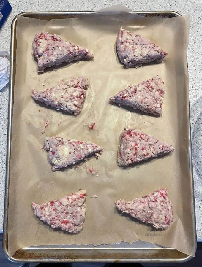 white chocolate raspberry scone dough wedges on baking sheet
